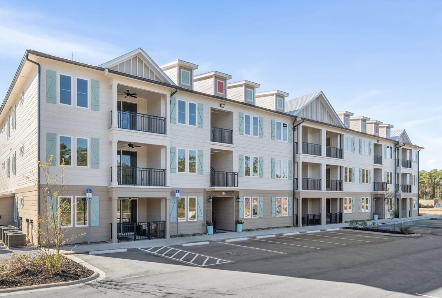 White condo building with balconies and pastel shutters near Point Preserve